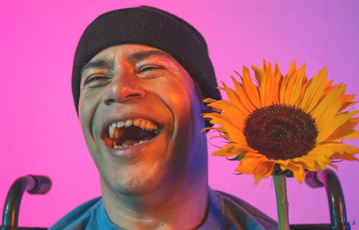A man smiling with a sunflowers